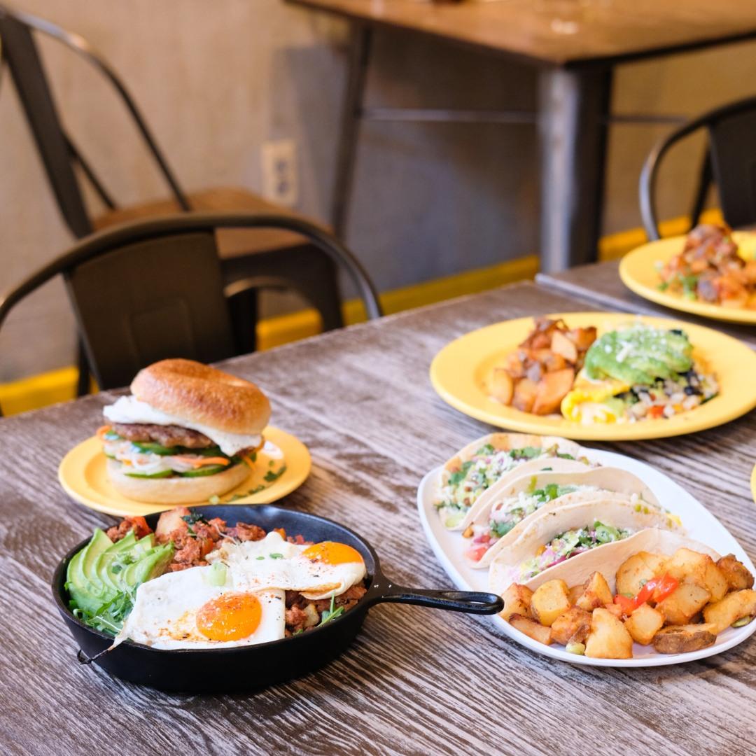 Delicious Eggcellent Cafe brunch spread with eggs, avocado, sandwiches and fresh dishes